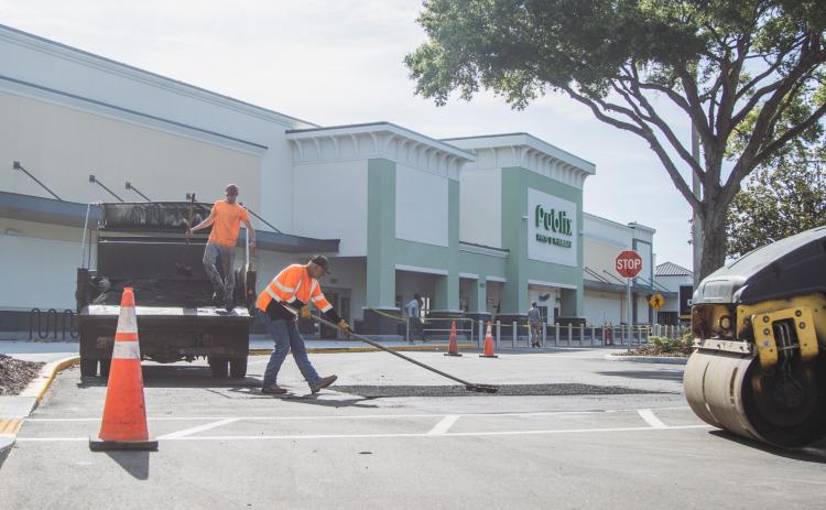 Donald Johnson, right, and Dalton Pinner of Duval Asphalt put finishing touches on the Publix parking lot Thursday. Johnson said they did all the paving and printing of the lot. Publix has officially announced it will open on July 2. Photo by Ashley Chandler/News-Leader