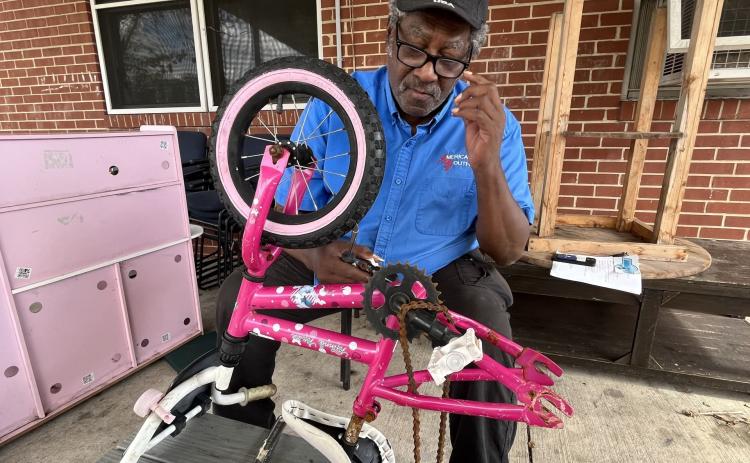 John Gilbert helps fix a bike. Submitted photo
