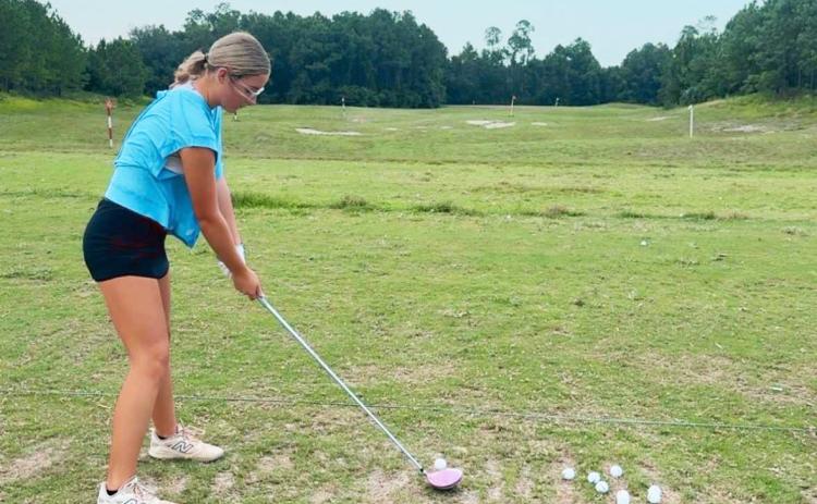 Lady Pirate golfer Harper Crews takes some swings at practice. Courtesy of YHS girls golf