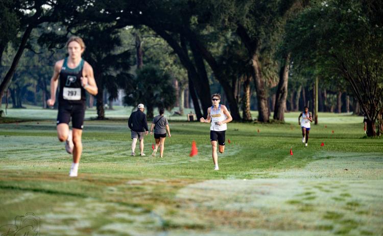 Fernandina Beach High School juniors John William Martin, middle, and Malik Ravenell, right, follow behind Providence senior Sean Cunningham on Saturday during the Coach Hope Memorial Invitational. The three runners finished first, second and third. Photo by Penny Glackin/For the News-Leader