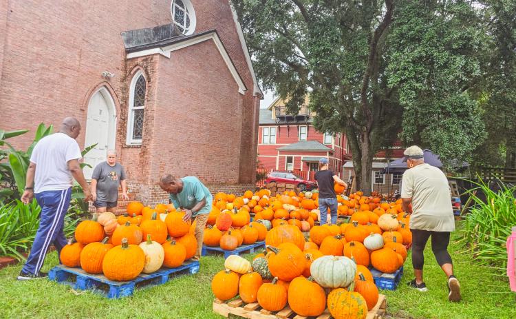 Serena Peterson, Trinity United Methodist Church outreach, far right, and Roschnell Brown, lay leader and the Wednesday service worship leader, far left, work with volunteers and staff to set up the pumpkin patch and fall activities Monday. The fall event will be open daily from noon to 6 p.m. until Oct. 31.