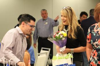 Project SEARCH instructor Lisa Mallo laughs with graduate Zachary Strickland at Tuesday’s ceremony.