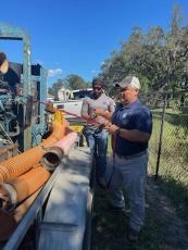 District Operations and Maintenance team members Quay Hix, front, and Harman Bansil, back, prepare to deploy pumps in Seminole County. Dale Doolittle and Travis Coston, not pictured, were also onsite to assist. Submitted photo.