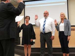 Shannon Hogue, Curtis Gaus and Lissa Braddock are sworn in as members of the Nassau County School Board by board attorney Brett Steger.