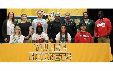 Yulee High School seniors, seated from left, Grace King, Jye Thompson, Josiah Evans and Chris Turner signed national letters of intent Wednesday to play their respective sport in college. They are pictured with their YHS coaches. Photo by Beth Jones/News-Leader