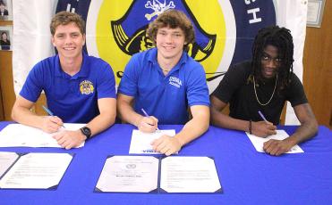 Jamieson Keith, Brooks Rohe and Andre Lucas signed national letters of intent to play their respective sport in college. Keith is a baseball player at Fernandina Beach High School, and Rohe and Lucas played football for the Pirates. They are pictured April 27 with friends, family and coaches at the spring signing day in the media center. Photo by Beth Jones/News-Leader