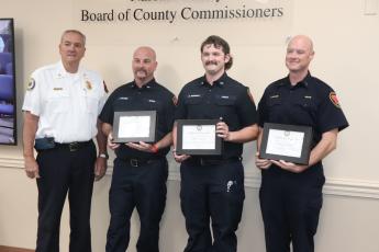 Three county firemen were recognized on Wednesday for a rescue involving a runaway car last November. From left, Fire Chief Brady Rigdon, Engineer Joseph McGee, Engineer Seth Newman and Lt. Mr. Jeremy McAlee. Submitted