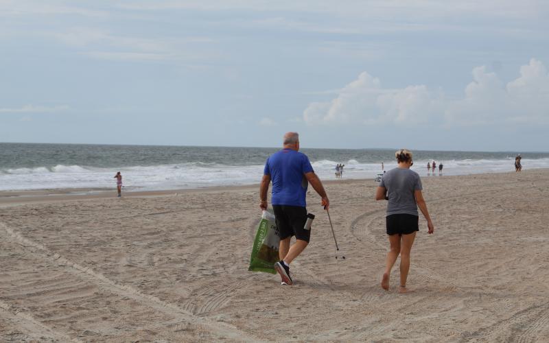 Volunteers keep an eye out for litter as they wander up Main Beach. Holly Dorman/News-Leader