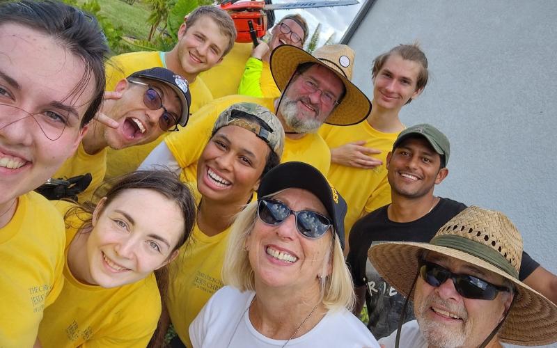 Volunteers from the Church of Jesus Christ of Latter-day Saints pose with Robert and Pam Nofye after helping dissemble their pool cage that collapsed in Hurricane Ian.