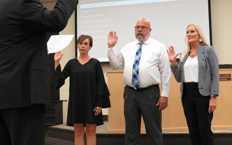 Shannon Hogue, Curtis Gaus and Lissa Braddock are sworn in as members of the Nassau County School Board by board attorney Brett Steger.