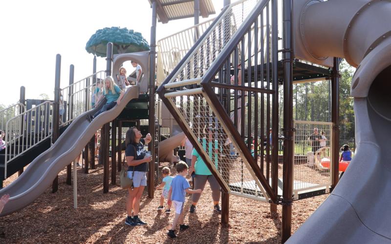 Families enjoy the new playground equipment after the ribbon-cutting ceremony.