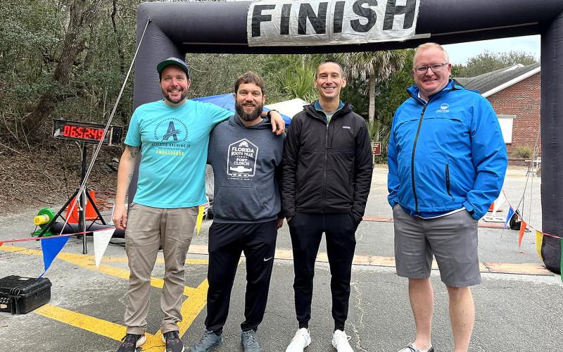 Florida Roots Trail Series foot race directors, from left, Daniel Larkin, Alex Johnston and Matt Mueller with Mike Brooks of First Port City Bank, which sponsored the winner’s awards,