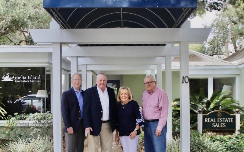 The staff and realtors of Amelia Island Real Estate stand proudly in front of their office.  Photo by Leah Jones/News-Leader