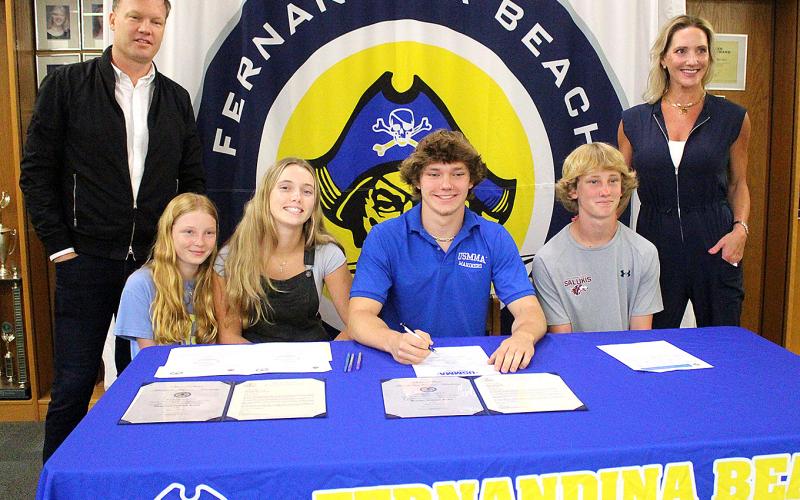 Jamieson Keith, Brooks Rohe and Andre Lucas signed national letters of intent to play their respective sport in college. Keith is a baseball player at Fernandina Beach High School, and Rohe and Lucas played football for the Pirates. They are pictured April 27 with friends, family and coaches at the spring signing day in the media center. Photo by Beth Jones/News-Leader