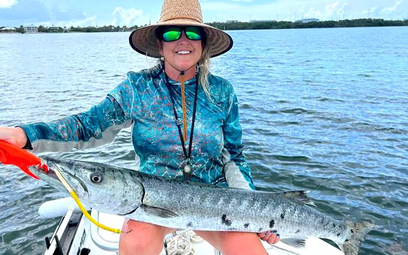 Harriet Durham, top, was tired of seeing a large barracuda steal her fish, so she picked up a nearby spinning rod and reel rigged with a tube lure and caught that pesky barracuda. Special photo