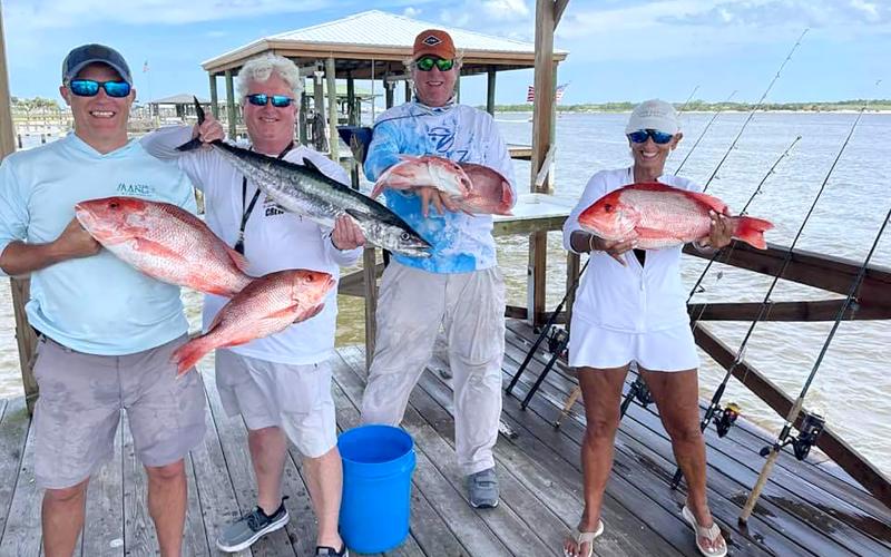 Matt Hampton, Greg Cook, Bill Fassbender and Pam Cook, from left, are pictured with a big red snapper and kingfish catch. Photo by Terry Lacoss