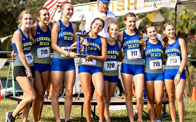 The Fernandina Beach High School girls cross country team celebrates its victory in the Coach Hope Memorial Invitational at the city golf course Saturday morning. The Lady Pirates bested the field of 20 teams, outscoring second-place Fletcher 23-105. Photo by Penny Glackin/Special