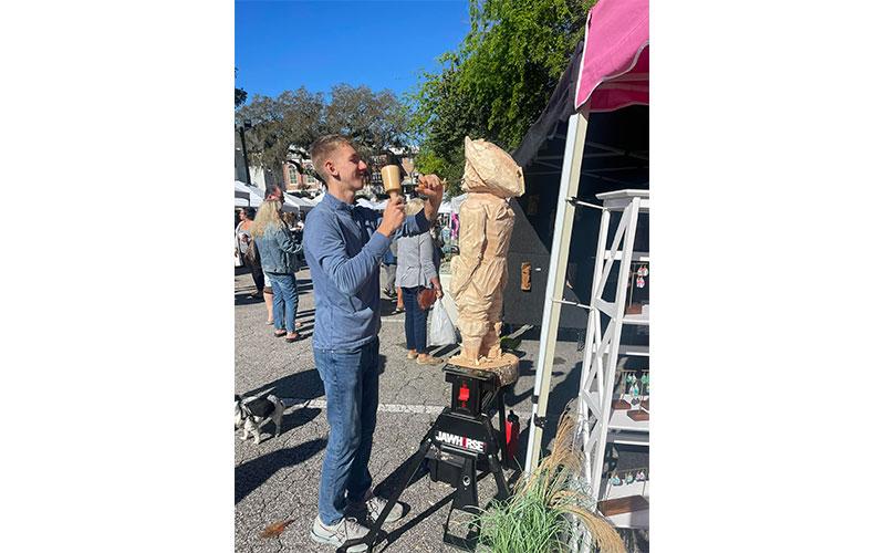 Jett Paxton creating a wood carving at the local Fernandina Beach Farmers Market. Submitted photo