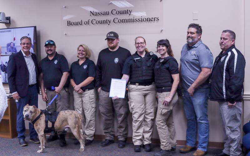 The Nassau County Board of County Commissioners proclaimed next week, April 14-20, as Animal Care & Control Appreciation Week in the county. Pictured are, from left, Vice Chairman A.M. “Hupp” Huppman and NCAC staff members M. Pruitt, C. Raulerson, L. Eckardt, W. Eberhardt, N. Laferriere, C. Thorton. T. Maguire and, at the bottom, Ted E. Bear, the dog. Photo by Ashley Chandler
