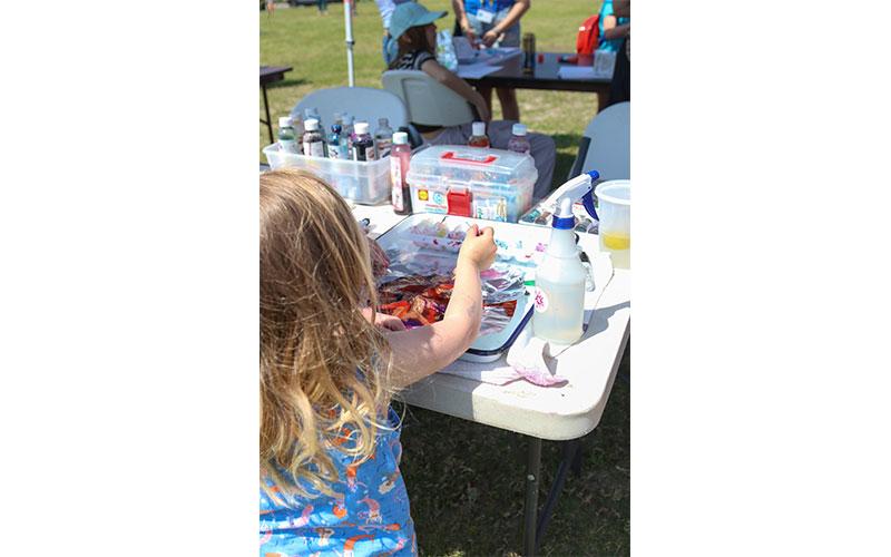Evie creates a masterpiece under the Arts Alive Nassau canopy Saturday during Earth Day Turtle Fest.  Photo by Ashley Chandler/News-Leader
